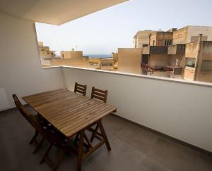 a wooden table and chairs in a room with a window at Dimora Mothia in Marsala