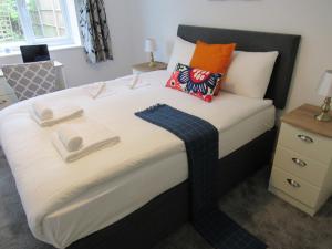 um quarto com uma cama com duas toalhas em The Cambridge Suites - Tas Accommodations em Cambridge