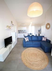 a living room with a blue couch and a tv at Dimora Mothia in Marsala +7 photos