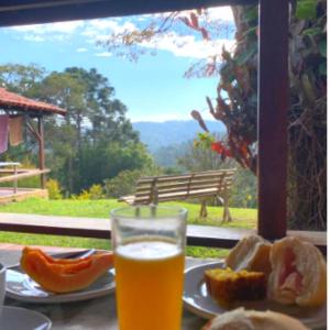 un vaso de cerveza sentado en una mesa con comida en Sitio Arco Iris da Lia, en São Roque