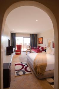 Habitación de hotel con cama y sala de estar. en Palais Riad Berbère en Marrakech