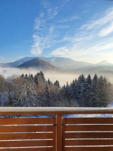 a view of a snowy mountain with a fence at A&M Apartment Donovaly in Donovaly