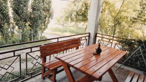a bird sitting on a wooden bench on a balcony at 202 in Bijelo Polje
