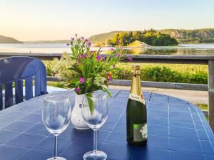 uma garrafa de vinho e dois copos numa mesa com flores em 4 person holiday home in HEN N em Henån