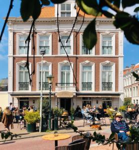 a building with people sitting at tables in front of it at La Paulowna Boutique Hotel in The Hague