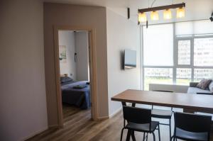 a room with a table and chairs and a bedroom at Kokos Avenue Loft Apartments in Yuzhne +7 photos