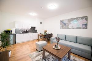 una sala de estar con un sofá y una mesa en Galeria Apartments, en Demänovská Dolina