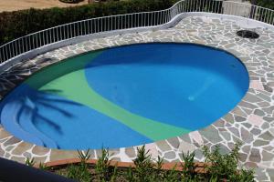 a large swimming pool with a green and blue at Gran Villa Costa Azul Acapulco in Acapulco