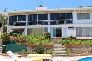 a building with a pool in front of it at Gran Villa Costa Azul Acapulco in Acapulco