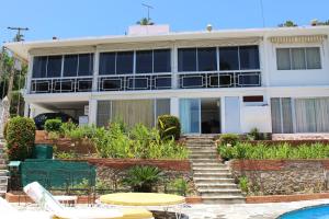 a building with a pool in front of it at Hermosa Residencia Costa Azul Acapulco in Acapulco