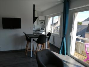 uma sala de estar com uma mesa e cadeiras e uma janela em Appartement proche mer et plage em Douarnenez