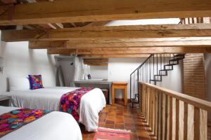ein Zimmer mit zwei Betten und eine Treppe mit einer Treppe in der Unterkunft Hacienda Molino Santo Domingo in San Cristóbal de las Casas