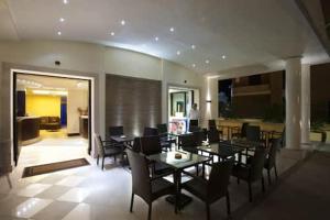 comedor con mesa y sillas y cocina en Villa Adriana Hotel en Tivoli