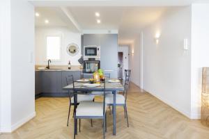 a kitchen and dining room with a table and chairs at Palais des Iles YourHostHelper in Cannes