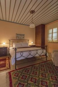 1 dormitorio con 1 cama en una habitación con alfombra en Αρχοντικό Βογιάρου, en Kalarites