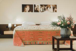 um quarto com uma cama com um vaso de flores sobre uma mesa em Residence Hotel em Vaduz