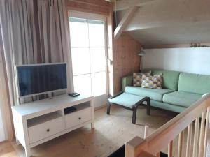 a living room with a couch and a tv at Ferienhaus Albrecht in Egg