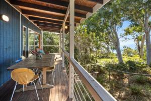 a deck with a wooden table and chairs on a house at Coral View in Point Lookout