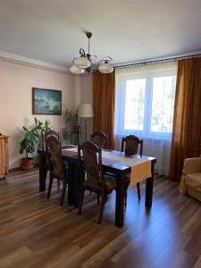 a dining room table and chairs in a living room at Zakątek in Porąbka