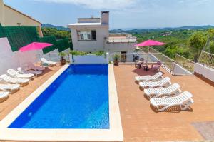 una piscina con tumbonas y una casa en Club Villamar - Rosario, en Lloret de Mar