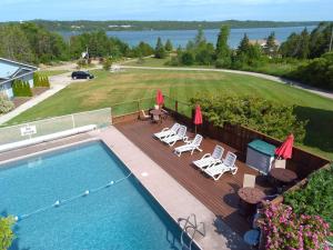an overhead view of a swimming pool with chairs and umbrellas at Waterview On The Bay in Wiarton