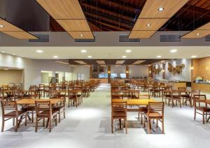 duża jadalnia ze stołami i krzesłami w obiekcie Apartamento Ondas Resort w mieście Porto Seguro