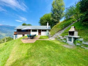 a house on top of a hill with a picnic table at Eco Lodge with Jacuzzi and View in the Swiss Alps in Grône