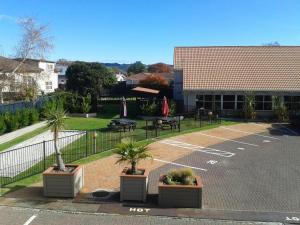 a parking lot with potted plants in front of a building at RotoVegas Motel of Rotorua in Rotorua