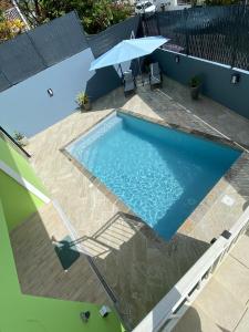 a swimming pool with an umbrella on a patio at La Villa Navidad in Ducos