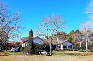 una casa con una mesa y una silla en el patio en GOLF - Casa de huéspedes en Tandil