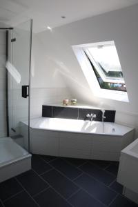 y baño con ducha y bañera con ventana. en Ferienwohnung Habitat en Gaggenau