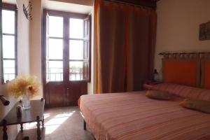 a bedroom with two beds and a large window at Casa Velainvento in Cefalù