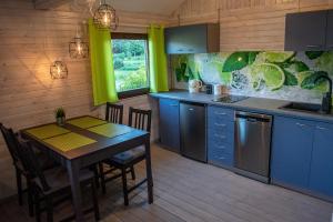 a kitchen with blue cabinets and a table with chairs at Stacja Wygoda in Lubiszewo