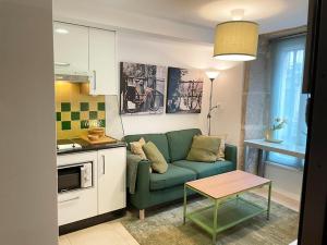 uma sala de estar com um sofá verde e uma mesa em Moss Home em Santiago de Compostela