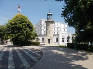 a white building with a clock tower on a street at Peninsula-Cazino,Dalvi in Constanţa