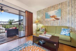Una sala de estar con un sofá verde y un televisor. en Kona Plaza#217, en Kailua-Kona