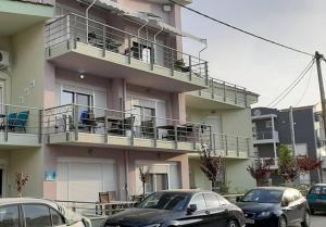 a building with cars parked in front of it at Onar View Studio in Néa Péramos