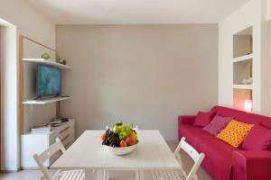 - un salon avec une table et un canapé rouge dans l'établissement ENJOY SORRENTO, à Sorrente