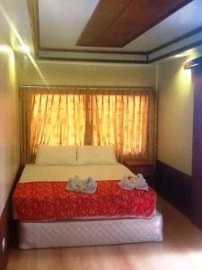 a bedroom with a bed with a red blanket and a window at Peach Guesthouse in Haad Rin