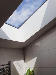 a skylight in the ceiling of a bathroom at Deluxe Spacious Apartment in Chadwell Heath, London in Goodmayes