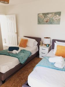a bedroom with two beds with towels on them at Deluxe Spacious Apartment in Chadwell Heath, London in Goodmayes