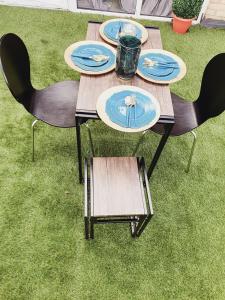einen Picknicktisch mit Stühlen und Platten auf dem Rasen in der Unterkunft Deluxe Spacious Apartment in Chadwell Heath, London in Goodmayes