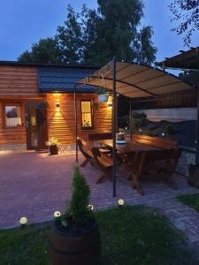 stół piknikowy pod parasolem na patio w obiekcie Apartamenty u Baców w mieście Ostrowsko