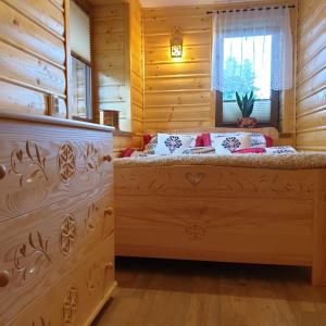 sypialnia z łóżkiem w chacie z bali w obiekcie Apartamenty u Baców w mieście Ostrowsko