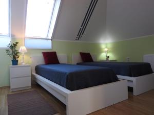 Töltéstava的住宿－Woldo Vendégház，一间卧室设有两张床和两个窗户。