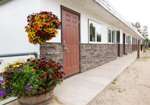 a building with a door and flowers in a pot at Alaska Frontier Inn in Delta Junction