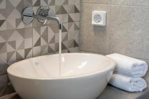 a bathroom with a sink and a faucet at Petra Aqua Villa in Perissa