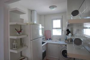 uma cozinha com um frigorífico branco e um lavatório em Apartamento-Solárium playa Marina de la Torre em Mojácar