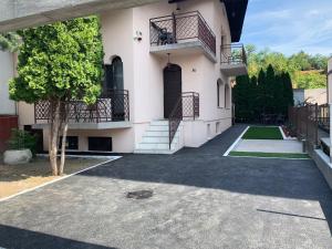 a large white house with a tree in front of it at Supilova Apartments in Belgrade