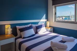 ein blaues Zimmer mit einem Bett und einem Fenster in der Unterkunft Central Marine Flat in Volos